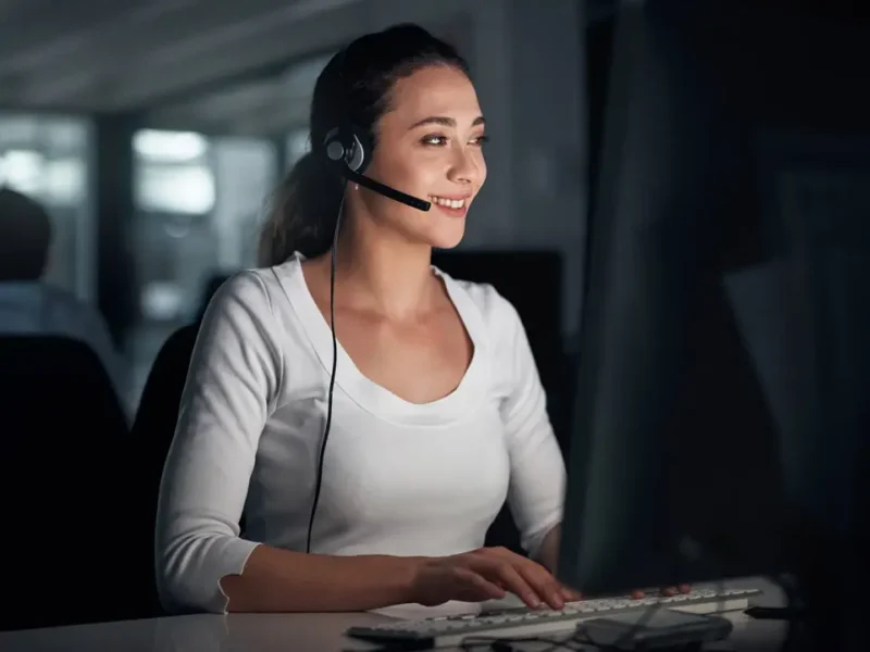 Woman at her desk providing after-hours call answering in the evening